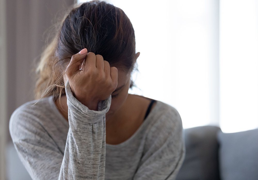 woman experiencing anxiety holding her head