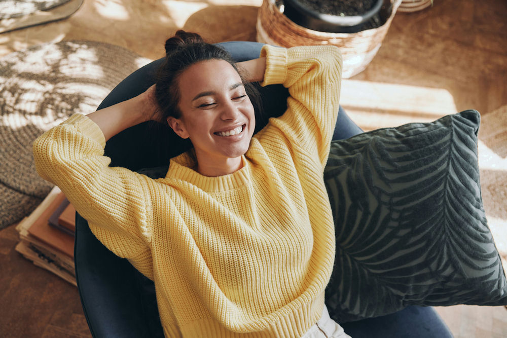 a-woman-smiling-laying-in-a-chair-happy