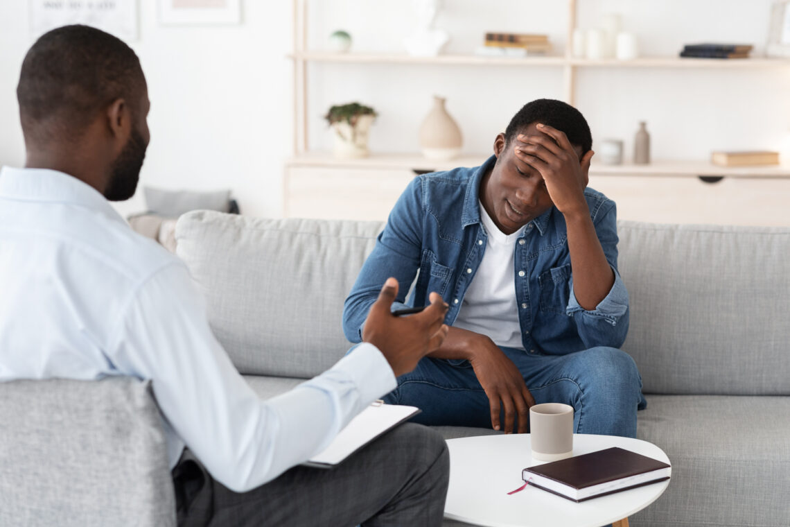 man-with-hand-on-head-in-therapy