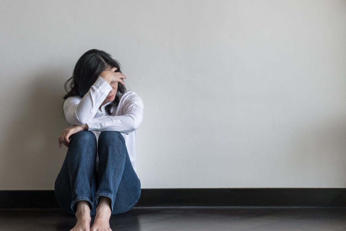 A woman hiding her face sitting down