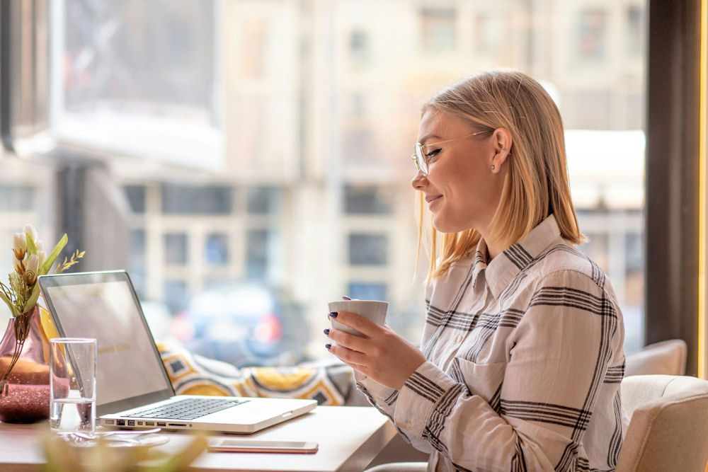 a-woman-smiling-working-on-a-laptop