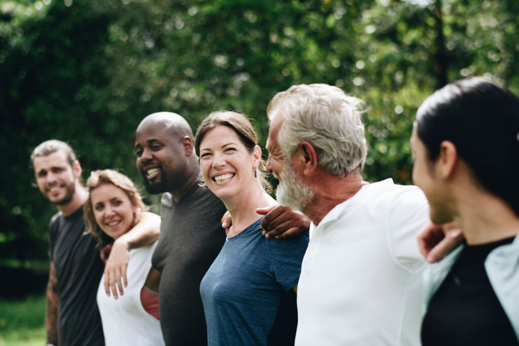 group outside with their arms around each other smiling