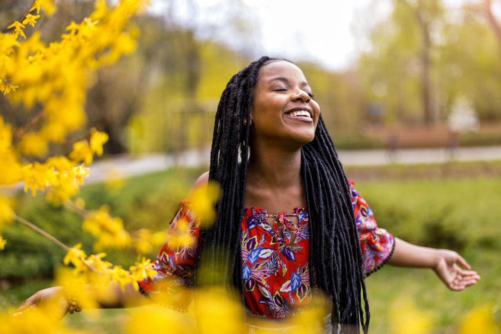 a-woman-smiling-surrounded-by-flowers