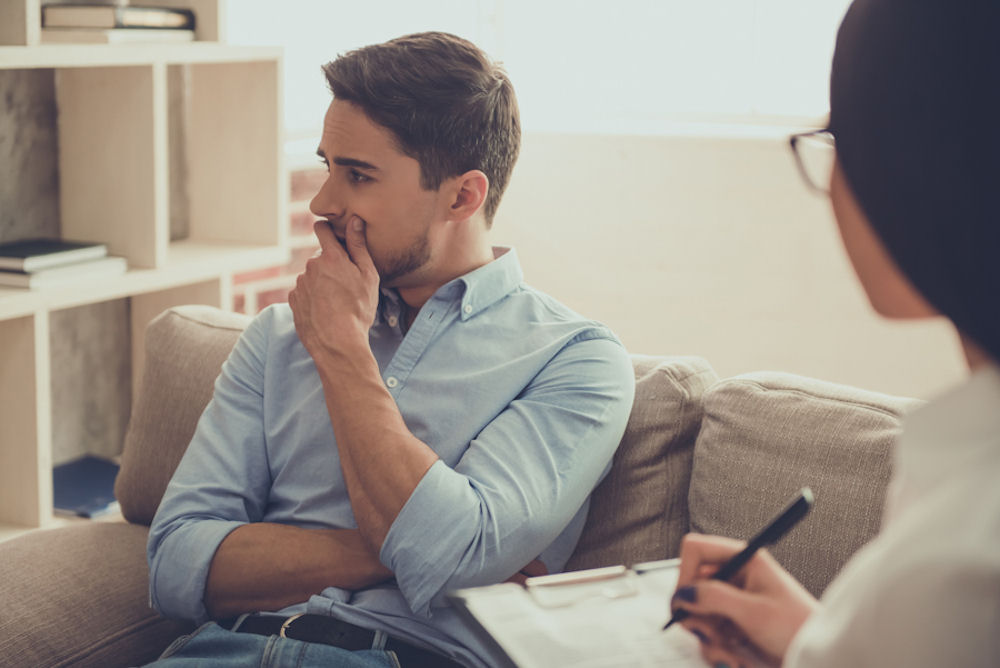 a man looking deep in thought while sitting in his therapy appointment