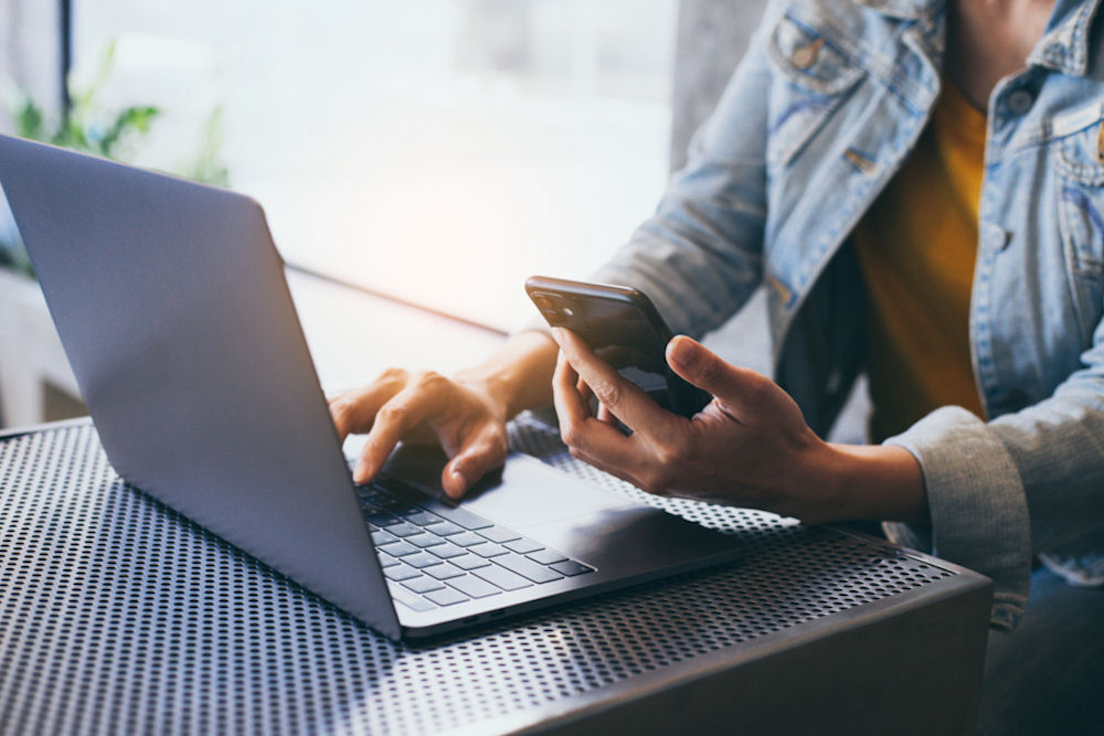 a woman with her laptop and phone contacting a mental health facility for voluntary admission