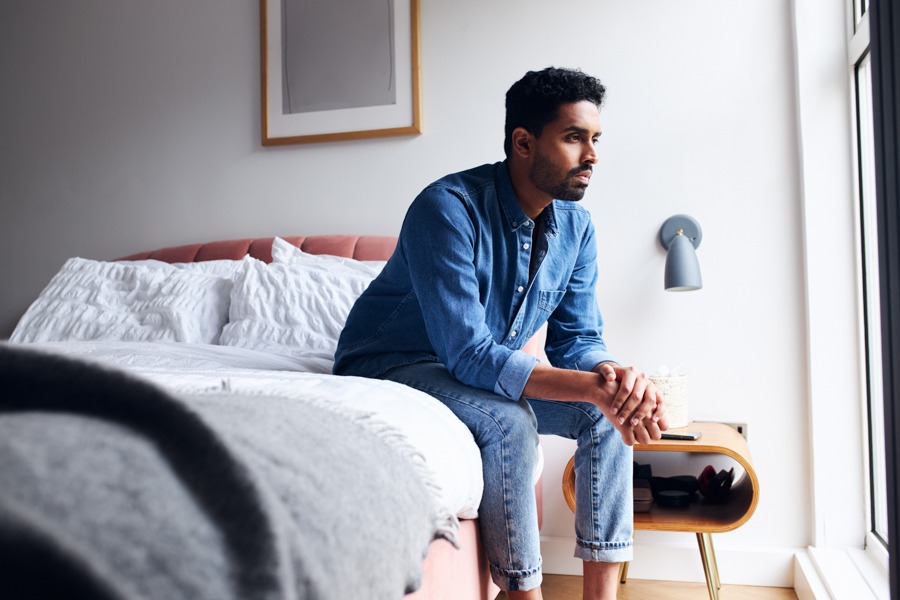 man sitting on bed struggling with a depressive episode