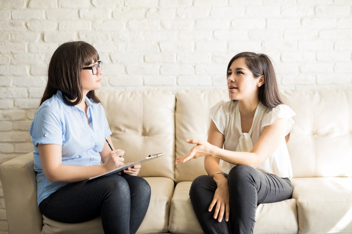 ocd-vs-bipolar-symptoms-guide woman sitting on a couch while talking to a therapist