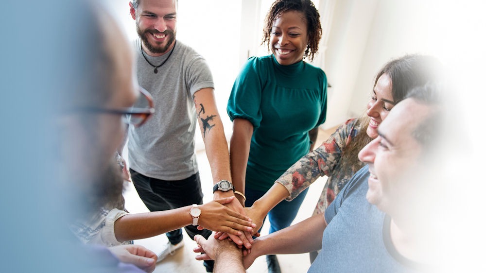 happy people in recovery, putting their hands together in a circle