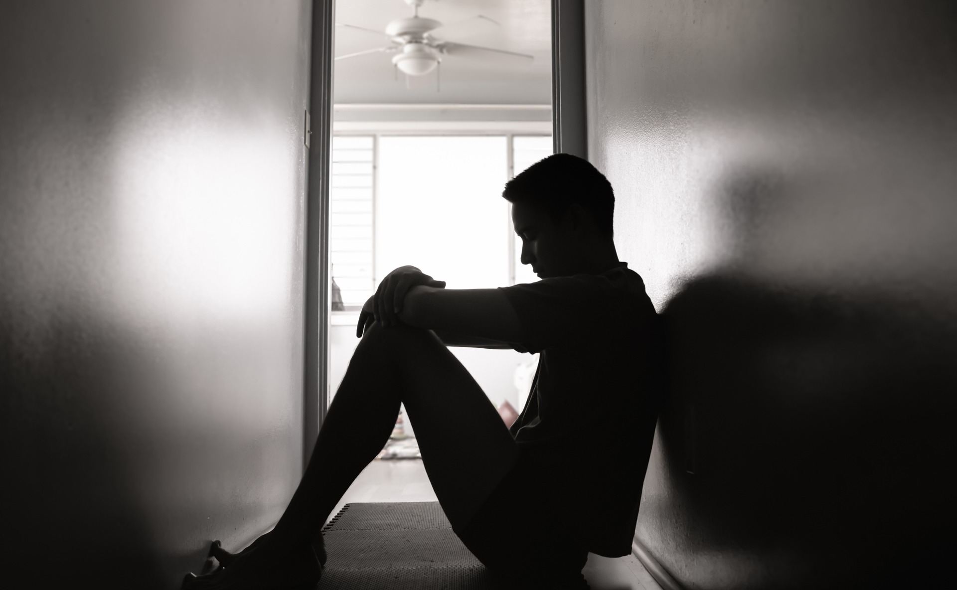 Person sitting alone in deep thought, representing the hidden effects of trauma in relationships.