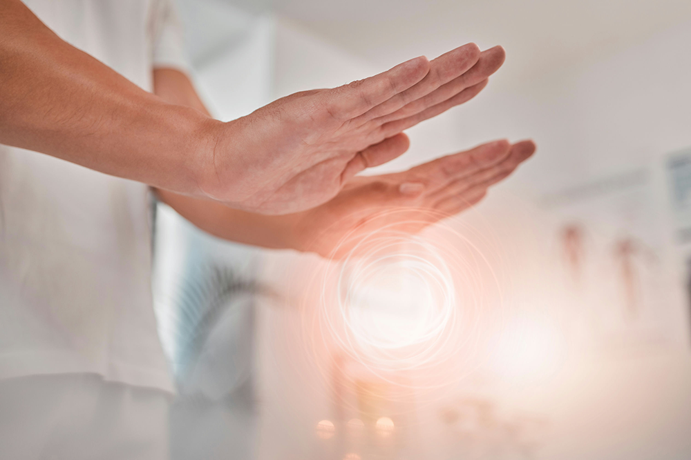 Hands hovering above the head during a Reiki session to promote relaxation and emotional balance.