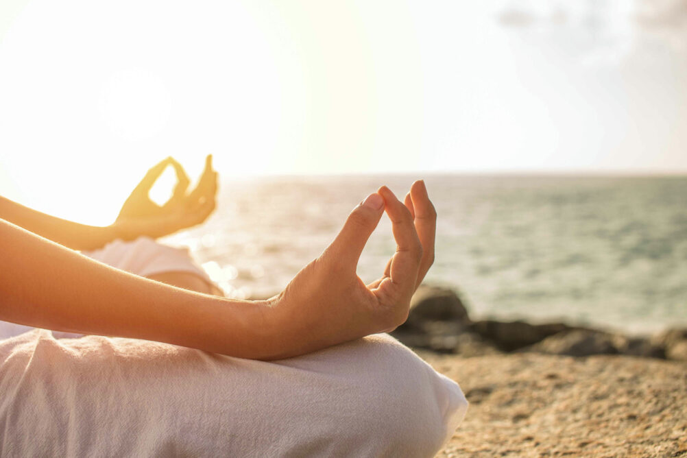 yoga-mental-health-therapy-nj hands in meditation position during yoga practice for stress management and relaxation
