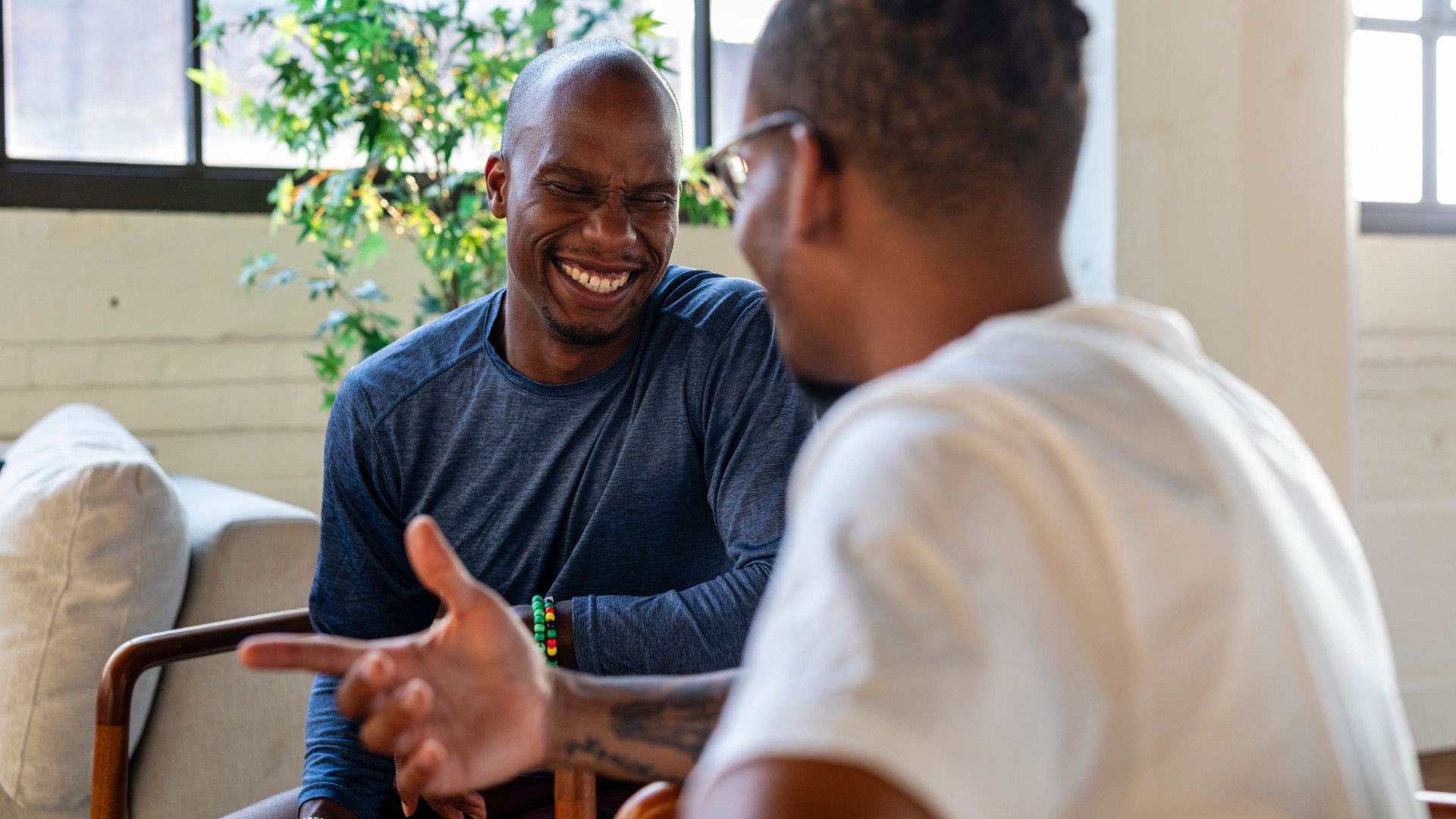 UnitedHealthcare Mental Health Coverage in NJ Two men smiling and talking during a counseling session covered by UnitedHealthcare mental health coverage in NJ.